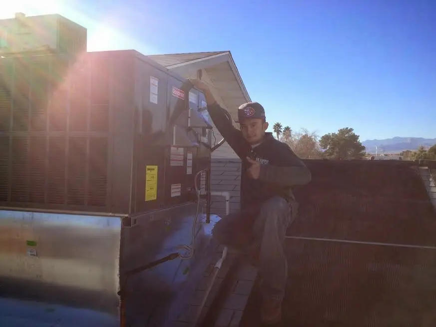 HVAC technician performing AC Tune-Up on a rooftop unit in Beverly Hills